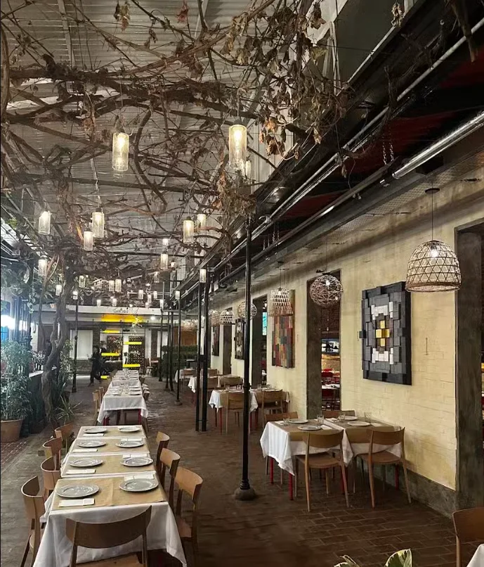 Salón principal de La Huella, con techo de parral y mesas largas