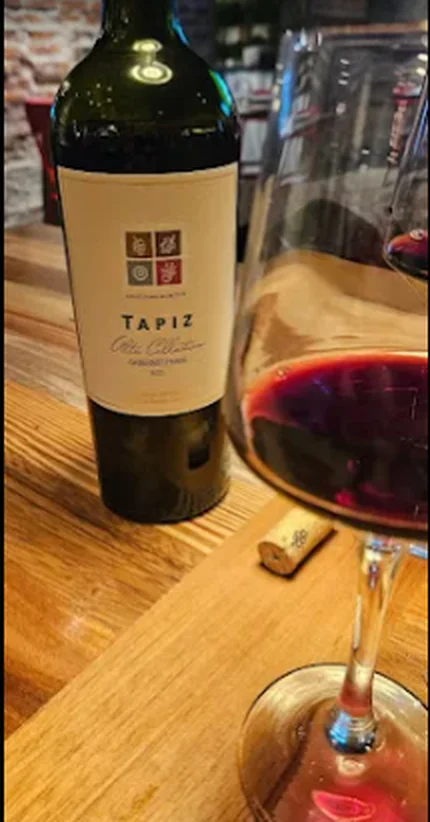Vino Tapiz Alta Colección junto a una copa servida